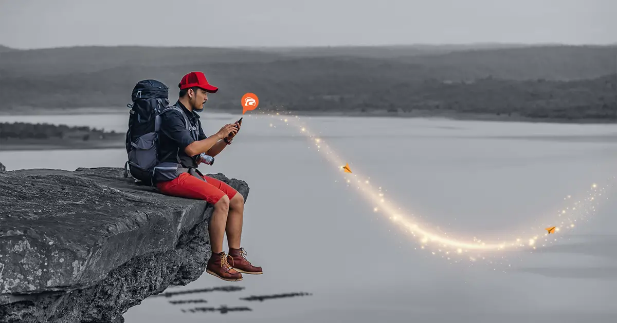 Student sitting in plain ground with mountain view at background.