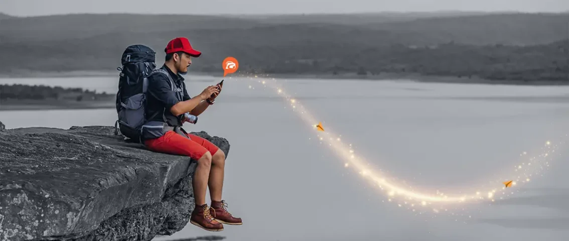 Student sitting in plain ground with mountain view at background.